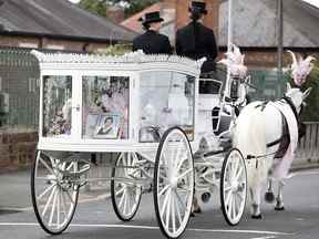 Une photo d'Olivia Pratt-Korbel, neuf ans, est vue avec son cercueil sur une calèche tirée par des chevaux lors de ses funérailles après avoir été tuée par balle chez elle, à Liverpool, en Grande-Bretagne, le 15 septembre 2022.