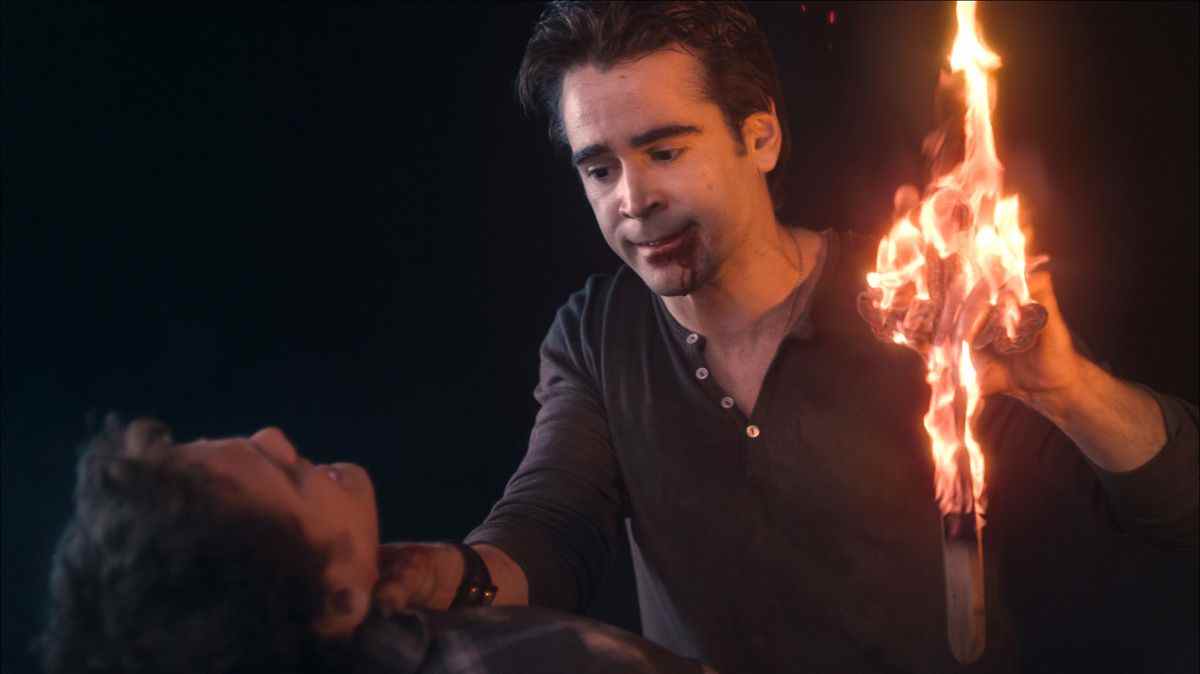 Un homme (Colin Farrell) avec du sang coulant de sa bouche alors qu'il étouffe un homme sur le capot d'une voiture d'une main tout en tenant une croix brûlante de l'autre main.