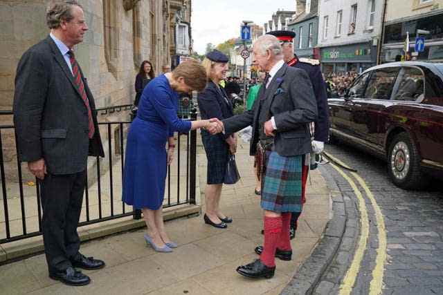 Le roi Charles III serre la main du premier ministre Nicola Sturgeon sous le regard du secrétaire écossais Alister Jack (à gauche), alors qu'il arrive à la City Chambers à Dunfermline, Fife, pour marquer officiellement l'attribution du statut de ville à l'ancienne ville