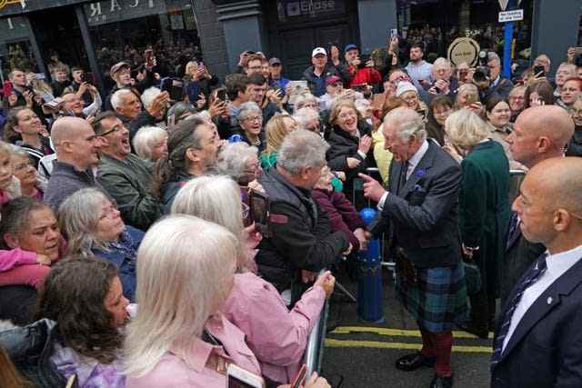 Le roi Charles III accueille les membres du public alors qu'il arrive à une réunion officielle du conseil à la City Chambers à Dunfermline, Fife, pour marquer officiellement l'attribution du statut de ville à l'ancienne ville, avant une visite à l'abbaye de Dunfermline pour marquer son 950e anniversaire