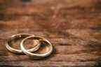 Une paire d'anneaux de mariage dorés sur fond de bois, espace de copie
