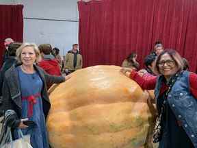 Rosie Kruhlak, à gauche, de St. Albert, et Pearl Bennett, à droite, d'Edmonton, posent à côté de la citrouille gagnante, pesant 2 537 livres, au Smoky Lake Pumpkin Fair samedi.