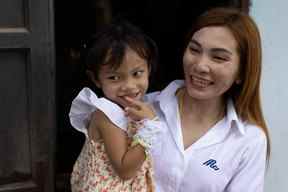 Panompai Sithong tient sa fille Paveenut Supolwong, surnommée Ammy, qui est la seule enfant survivante de la fusillade de masse dans la garderie, lors d'une réunion de famille à leur domicile à Uthai Sawan, province de Nong Bua Lam Phu, Thaïlande, le 9 octobre 2022.