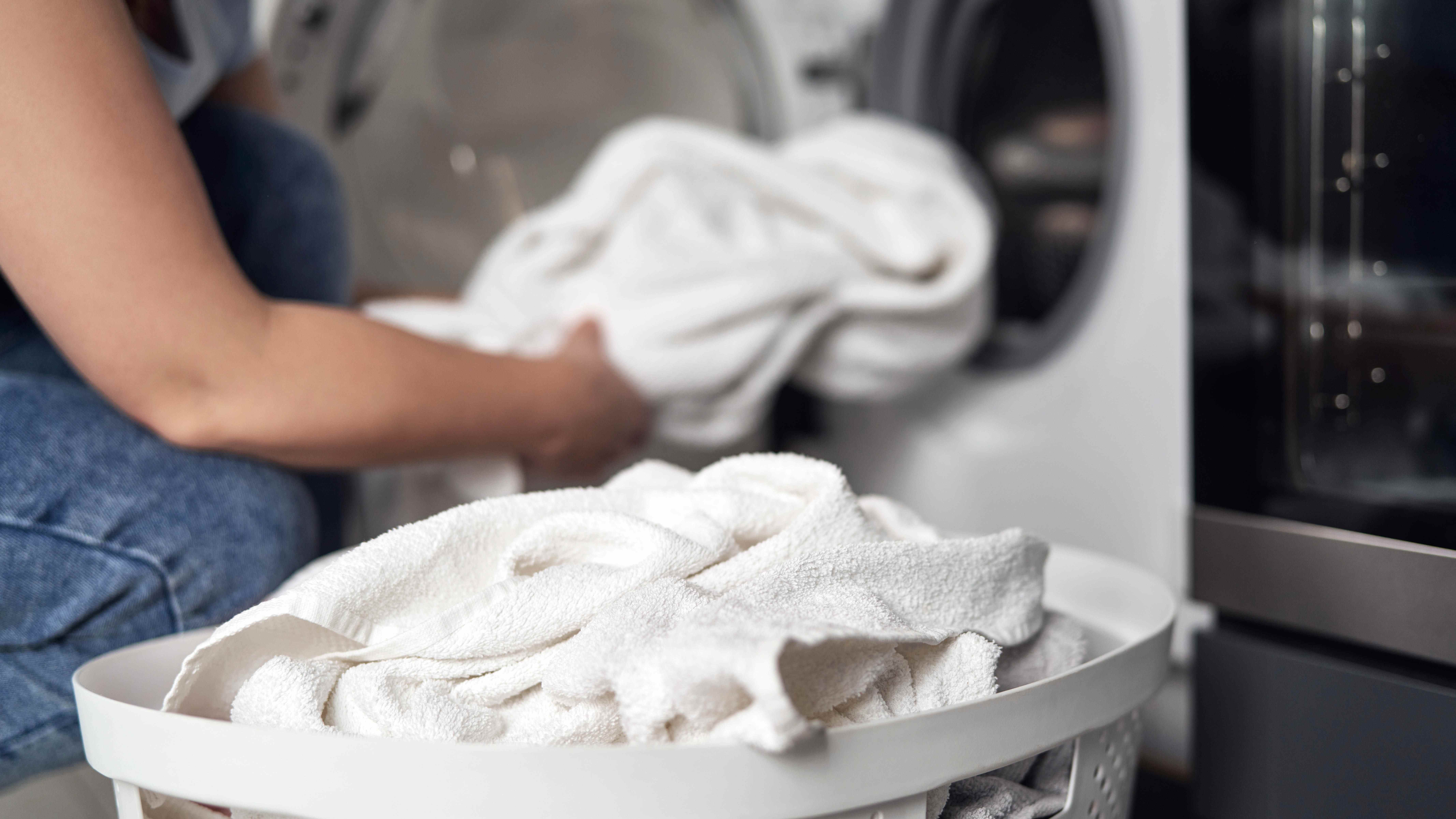 Chargement des serviettes blanches dans la machine à laver