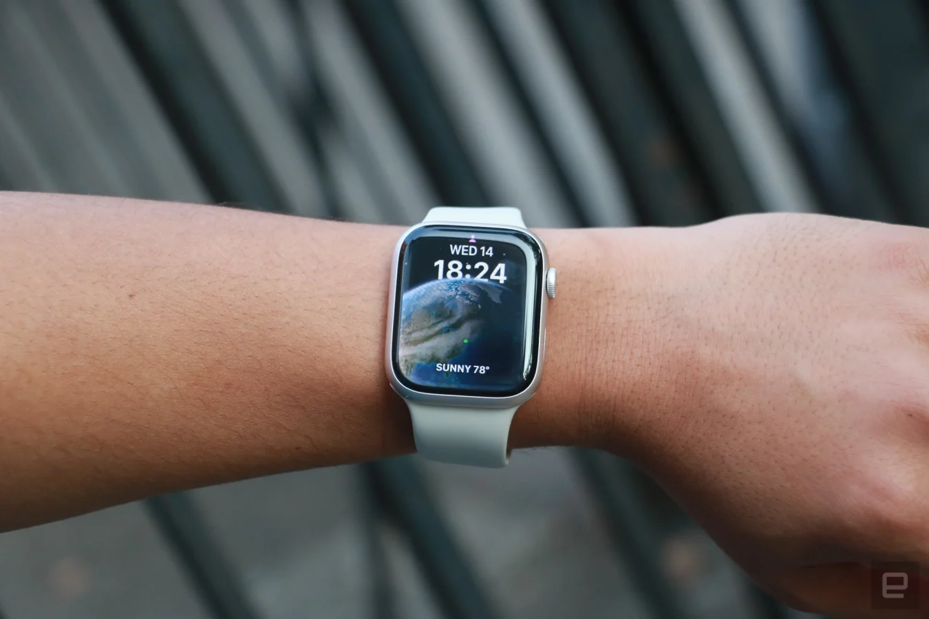 L'Apple Watch Series 8 sur un poignet tenu en l'air.