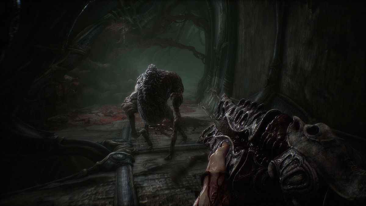 Le personnage du joueur pointe le fusil de chasse d'aspect gothique sur un monstre qui s'approche d'eux dans Scorn