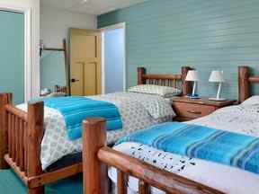 Le revêtement bleu sarcelle et les gros meubles en rondins de Pioneer Handcraft charment l'une des chambres.