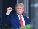 L'ancien président américain Donald Trump lève le poing en marchant vers un véhicule à l'extérieur de la Trump Tower à New York le 10 août 2022. (Photo par STRINGER / AFP) 