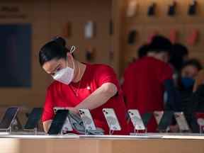 Un employé nettoie des iPhones dans un Apple Store à San Francisco.