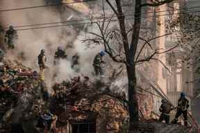 Des pompiers ukrainiens travaillent sur un bâtiment détruit après une attaque de drone à Kyiv le 17 octobre 2022, au milieu de l'invasion russe de l'Ukraine.  (Photo de YASUYOSHI CHIBA/AFP via Getty Images)
