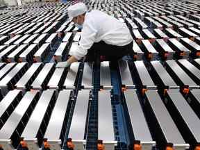 Un ouvrier avec des batteries de voiture dans une usine de Xinwangda Electric Vehicle Battery Co. Ltd, qui fabrique des batteries au lithium pour les voitures électriques et d'autres usages, à Nanjing, dans la province orientale du Jiangsu en Chine.