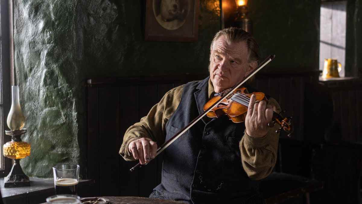 Colm (Brendan Gleeson) joue du violon à une table du pub local dans The Banshees of Inisherin