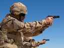 Des membres de la Police militaire et de la Force de sécurité du secteur s'entraînent à tirer avec le pistolet Browning 9 mm à genoux au champ de tir lors de l'opération IMPACT le 4 mars 2015. Photo : OP Impact, MDN 