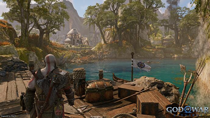 Aperçu de God of War - Kratos marche le long d'une jetée en bois dans le royaume nain en regardant l'eau turquoise et les arbres moussus verts