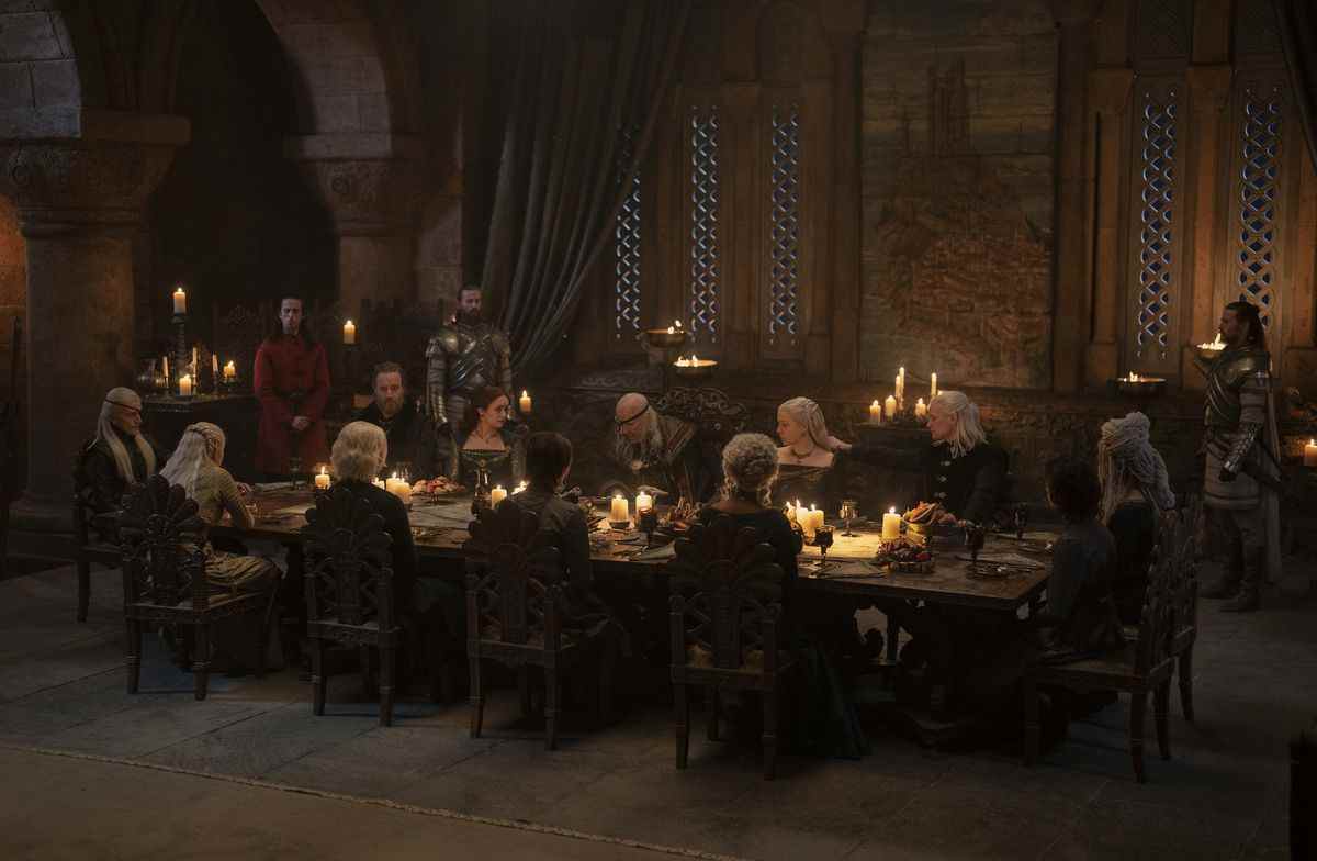 Aemond (Ewan Mitchell) assis à la tête d'une table avec le reste de sa famille, y compris Targaryens, Velaryons et Hightowers