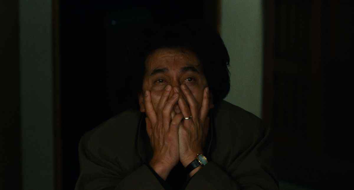 Le détective Takabe (Kôji Yakusho) serre ses mains sur son visage d'épuisement et d'horreur dans Cure (1997)