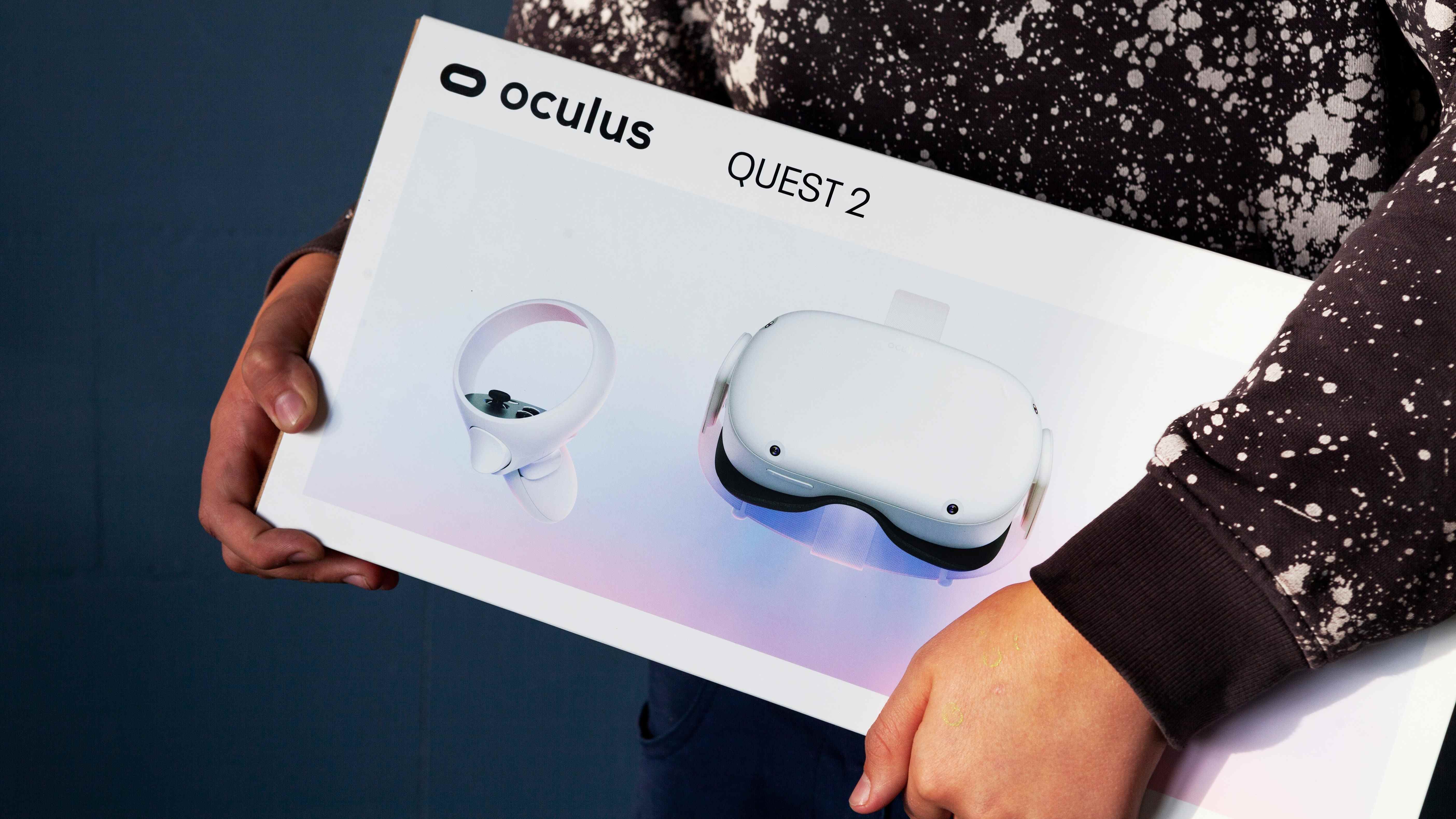 Une personne transportant une boîte avec un casque VR Oculus Quest 2 dans