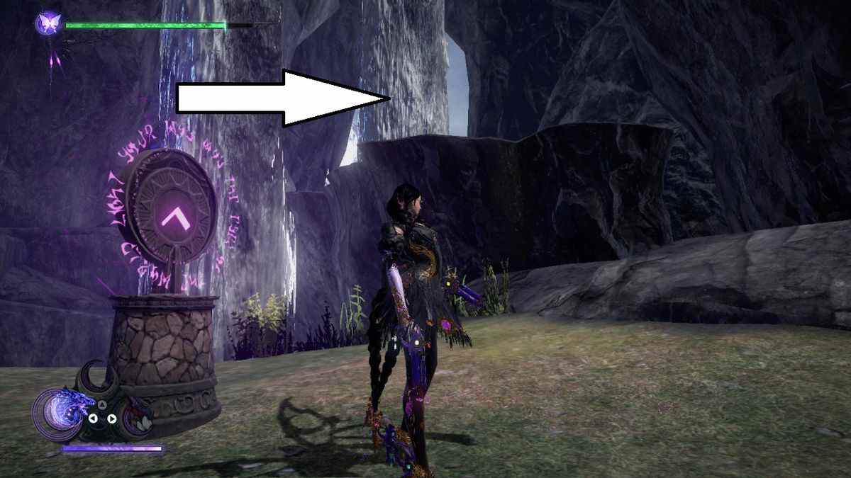 Bayonetta se tient dans une grotte derrière une cascade à côté d'un pendentif à Bayonetta 3.