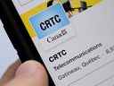 Une personne navigue sur les pages de médias sociaux en ligne du Conseil de la radiodiffusion et des télécommunications canadiennes (CRTC) sur un téléphone cellulaire à Ottawa le lundi 17 mai 2021. LA PRESSE CANADIENNE/Sean Kilpatrick