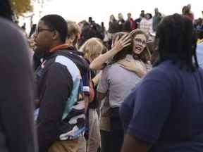 Les gens se rassemblent à l'extérieur après une fusillade au lycée Central Visual and Performing Arts de Saint-Louis, le lundi 24 octobre 2022.