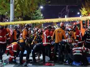 Des secouristes et des pompiers travaillent sur les lieux d'un accident écrasant à Séoul, en Corée du Sud, le samedi 29 octobre 2022.