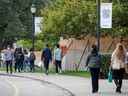Des étudiants marchent sur le terrain du campus de l'Université de Toronto à Toronto.