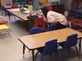 Dans cette capture d'écran d'une vidéo publiée sur Facebook, une éducatrice est photographiée en train de faire peur avec un enfant.
