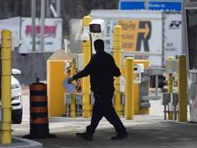 Un agent frontalier passe devant des caméras de sécurité à la frontière des Mille-Îles, près de Gananqoue, en Ontario, le lundi 16 mars 2020.