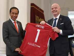 Le président indonésien Joko Widodo tient un maillot avec le président de la FIFA Gianni Infantino après leur rencontre au palais de Jakarta, en Indonésie, le 18 octobre 2022, sur cette photo prise par Antara Foto.
