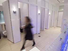 Une femme entre dans des toilettes pour hommes et femmes du centre commercial Yorkdale à Toronto, le mardi 11 décembre 2018.