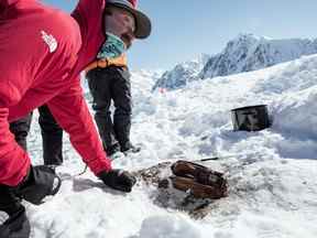 Griffin Post examine des parties d'une cache vieille de 85 ans appartenant au célèbre explorateur Bradford Washburn sur une photo à distribuer.  Post a dirigé l'équipe qui a découvert la cache sur le glacier Walsh du Yukon.