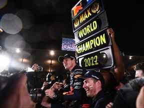 Le pilote néerlandais de Red Bull Racing Max Verstappen, au centre, célèbre sa victoire au championnat du monde de la saison après sa victoire au Grand Prix du Japon de Formule 1 à Suzuka, préfecture de Mie, le 9 octobre 2022.
