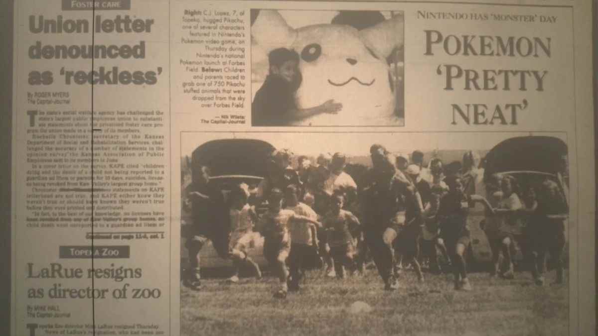 Une ancienne édition du Topeka Capital Journal, avec une coloration sépia.  Une petite image montre un enfant étreignant une peluche géante Pikachu.  Le lecteur de titre 