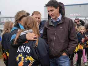 Le premier ministre Justin Trudeau s'entretient avec une personne de l'équipe de hockey féminin U13 de Port Aux Basques à la suite de l'ouragan Fiona à Port Aux Basques, Terre-Neuve-et-Labrador, le 28 septembre 2022.