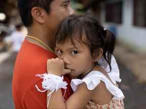 Tawatchai Supolwong tient sa fille Paveenut Supolwong, le seul enfant survivant de la fusillade de masse à Uthai Sawan