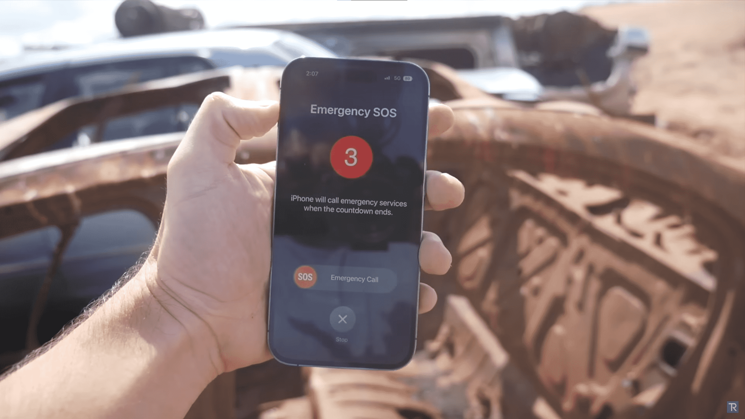 Une image d'un iPhone 14 Pro affichant une notification SOS d'urgence après un accident de voiture simulé