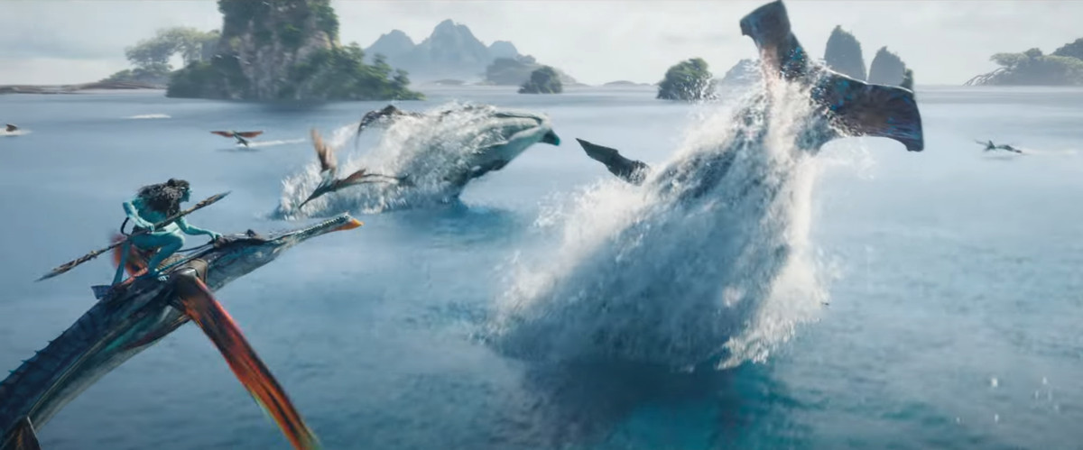 Un Na'vi chevauche un poisson volant géant, tenant une lance, alors que de vastes baleines extraterrestres sautent d'un paysage marin