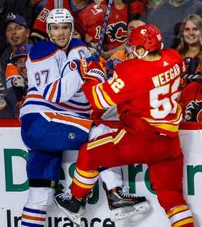 L'attaquant des Oilers d'Edmonton Connor McDavid entre en collision avec MacKenzie Weegar lors du match de samedi.