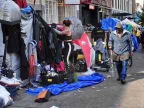 Les gens font leurs valises alors que les autorités appliquent un ordre de dégager les tentes occupées par des sans-abri des trottoirs du Downtown Eastside de Vancouver le 9 août 2022.