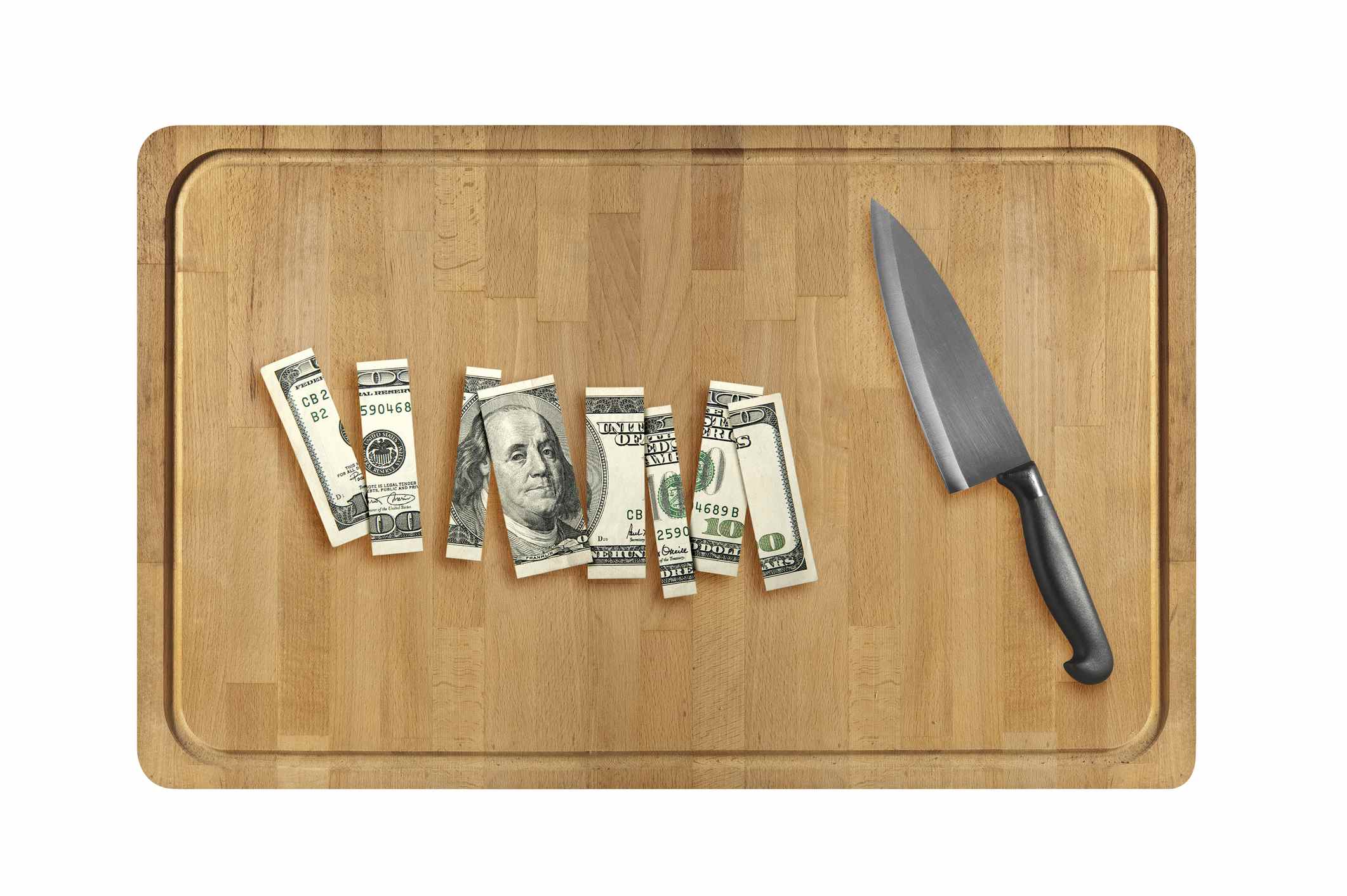Couteau et tranches de cent dollars sur une planche à découper en bois.  isolé sur fond blanc.