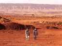 Deux astronautes marchent dans des combinaisons spatiales lors d'une mission d'entraînement pour la planète Mars.