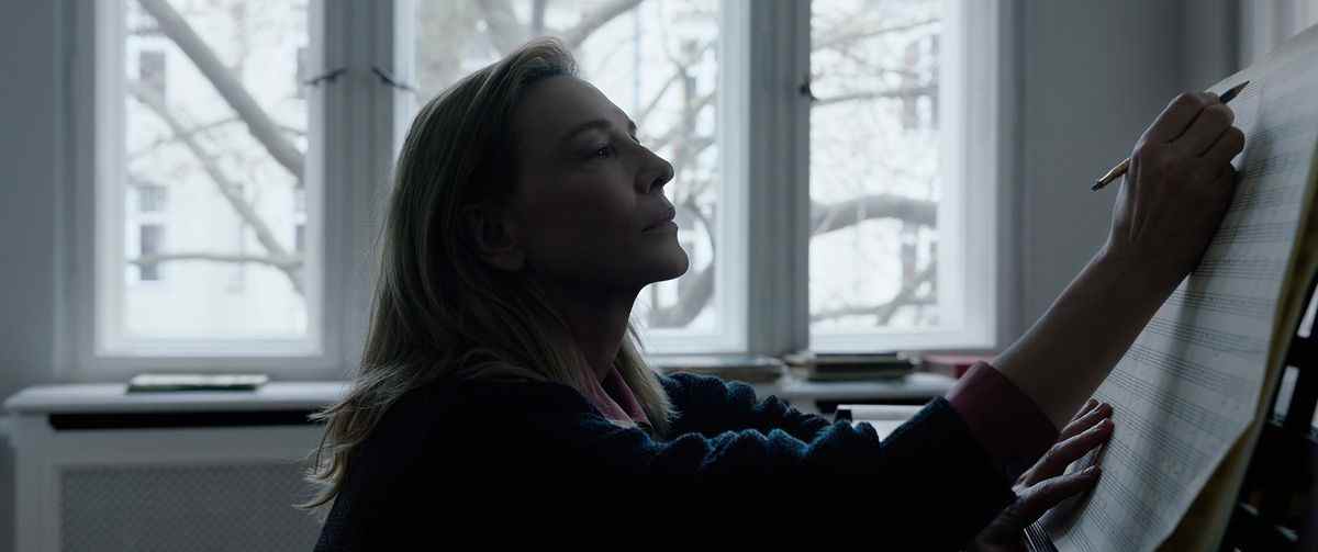 Lydia Tár (Cate Blanchett) composant au piano dans une pièce faiblement éclairée dans Tár de Todd Field
