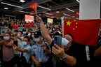 Des supporters agitent des drapeaux nationaux chinois en attendant l'arrivée du dirigeant de Huawei, Meng Wanzhou, à l'aéroport international de Bao'an à Shenzhen.