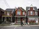 Un cycliste passe devant une rangée de maisons à Toronto.
