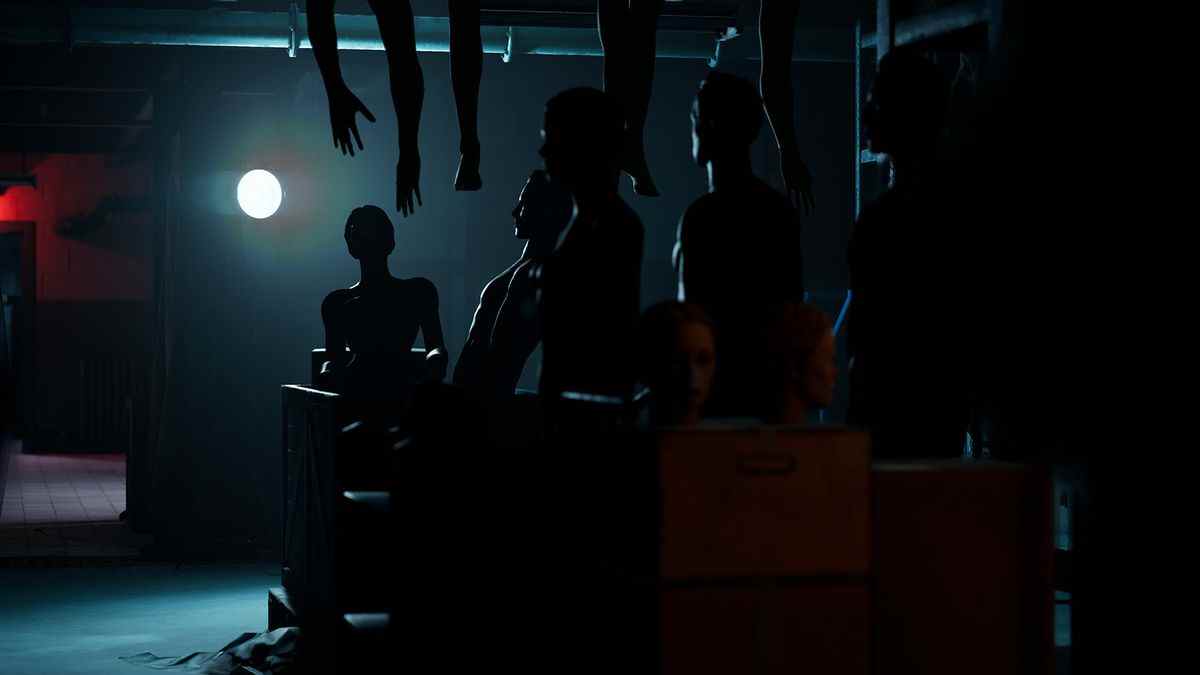 The Dark Pictures Anthology: The Devil In Me - Une jeune femme transporte une boîte dans une pièce sombre.  Des pièces de mannequin pendent du plafond, bloquant la lumière.