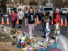 Les personnes en deuil visitent un mémorial à l'extérieur du Club Q à Colorado Springs, Colorado, le mardi 22 novembre 2022.