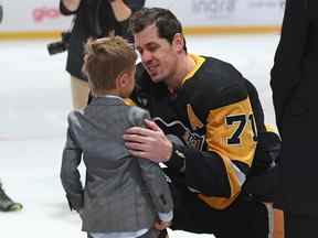 L'attaquant des Penguins de Pittsburgh Evgeni Malkin s'entretient avec son fils Nikita lors d'une cérémonie honorant le 1 000e match en carrière de Malkin dans la LNH avant le match contre les Flames de Calgary au PPG Paints Arena de Pittsburgh le mercredi 23 novembre 2022.