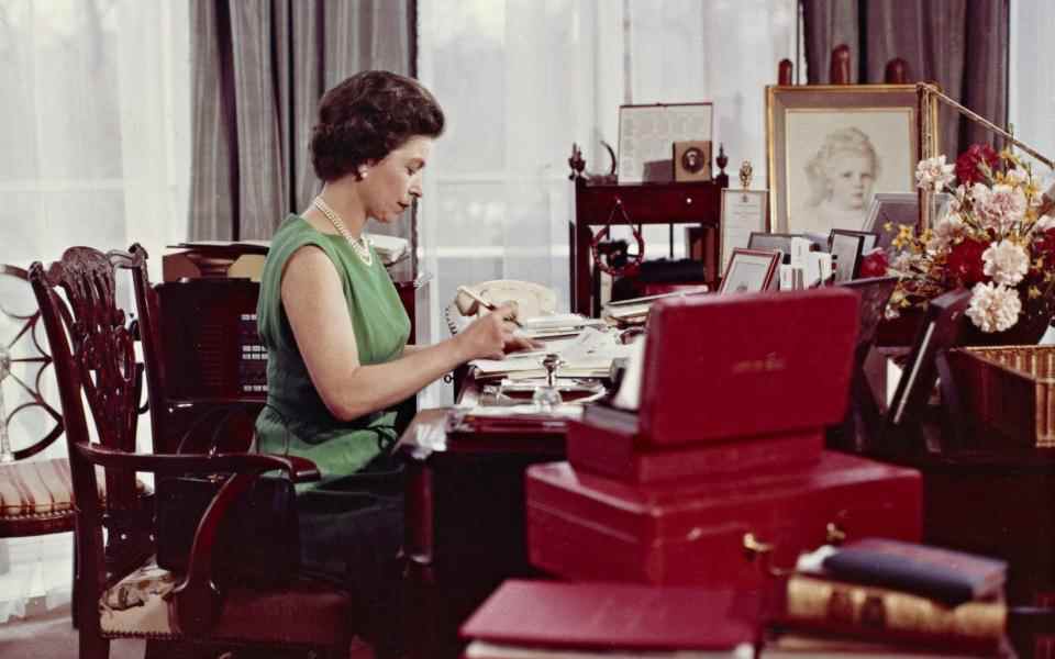 La reine Elizabeth à son bureau au palais de Buckingham avec une boîte d'expédition rouge en 1968 - LA COLLECTION ROYALE.  Joan Williams