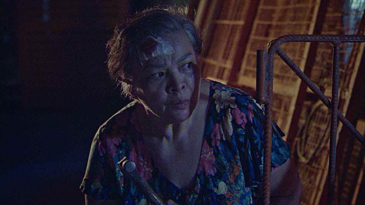 Leonor (Sheila Francisco), une Philippine âgée avec un bandage ensanglanté sur la tête, se cache dehors la nuit, l'air suspect dans Leonor ne mourra jamais