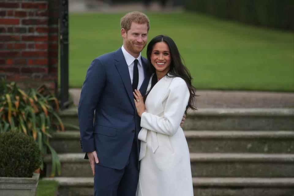 Le prince Harry porte un costume bleu et Meghan Markle porte un manteau blanc pour annoncer leurs fiançailles en 2018. (Getty Images)
